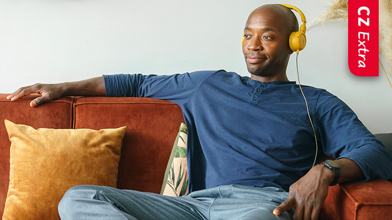 Jongen zit op de bank muziek te luisteren